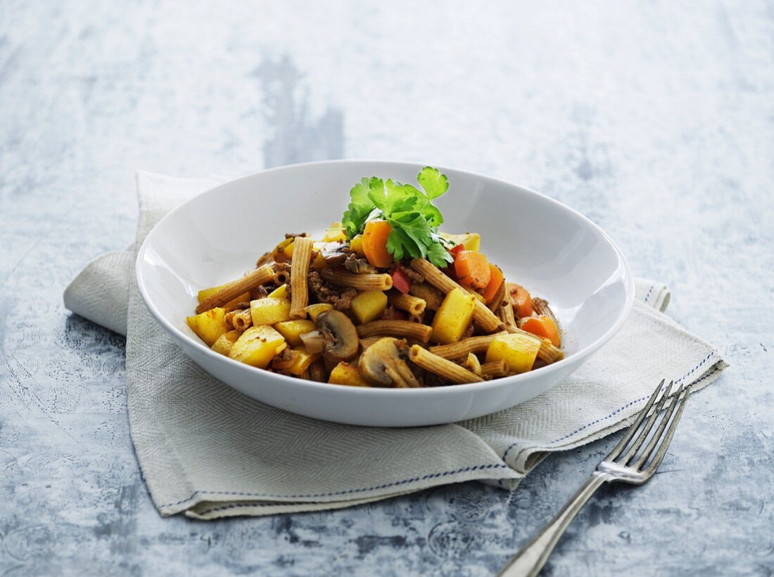 Vegetable stew with beef, mushrooms and pasta on a plate