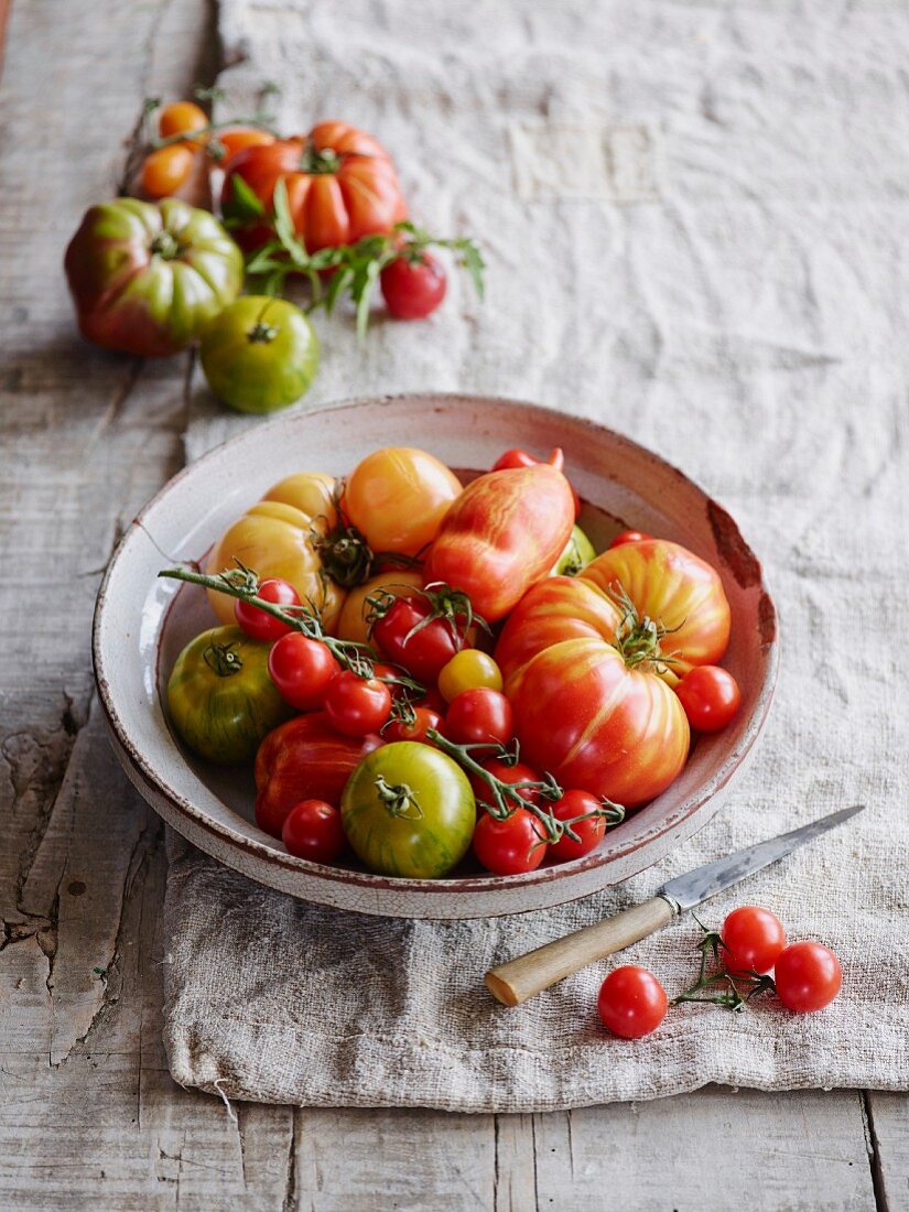 Various types of tomatoes in a ceramic bowl