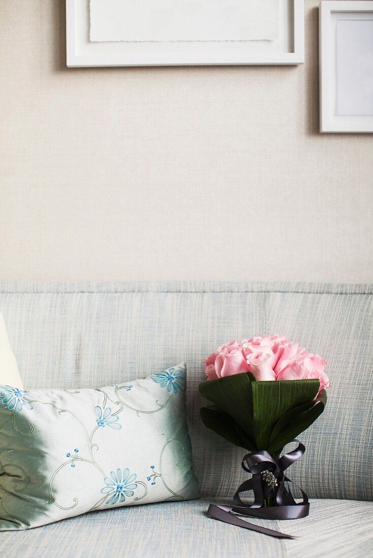 Bouquet of roses on sofa next to silver scatter cushion