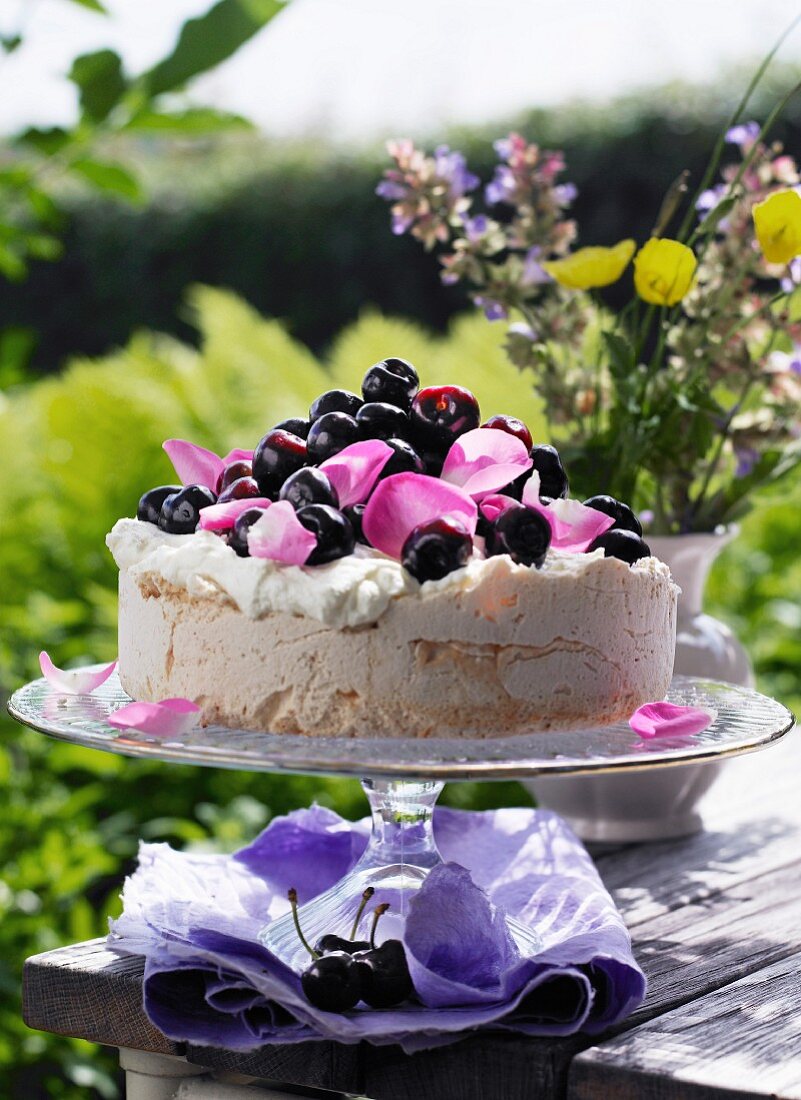 Meringue cake with cherries and rose petals