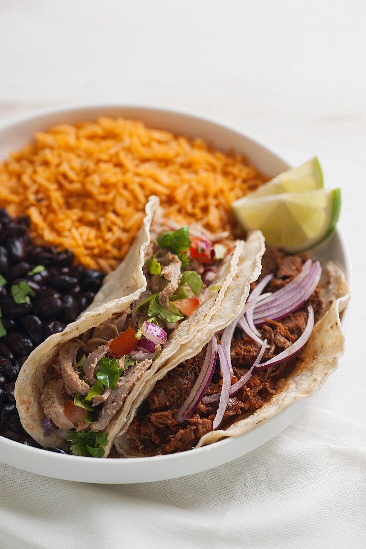 Tacos mit verschiedenen Fleischfüllungen, schwarzen Bohnen und Tomatenreis