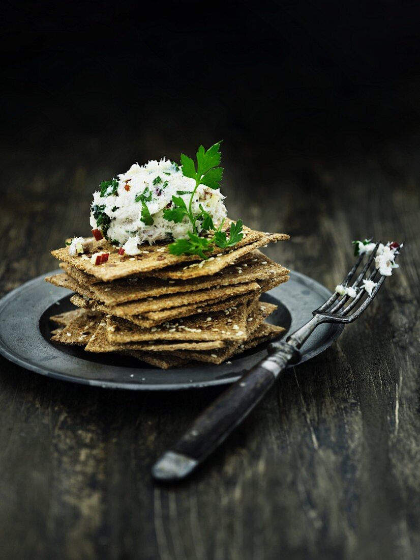 A stack of wholemeal crispbread and crabmeat salad with apple pieces