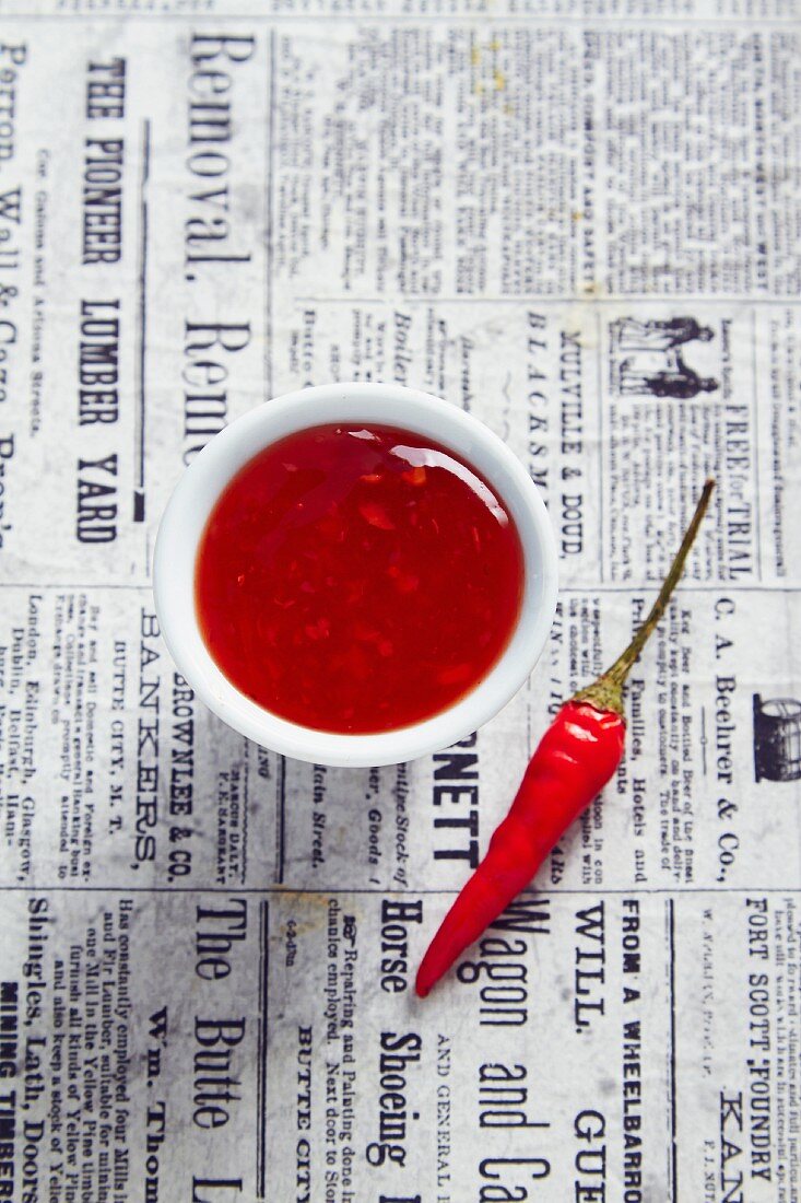 A bowl of chilli chutney on a newspaper