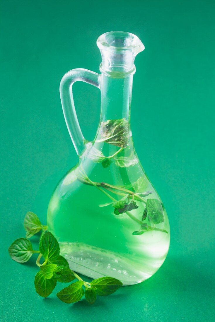 Minzsirup in einer Flasche auf grünem Untergrund