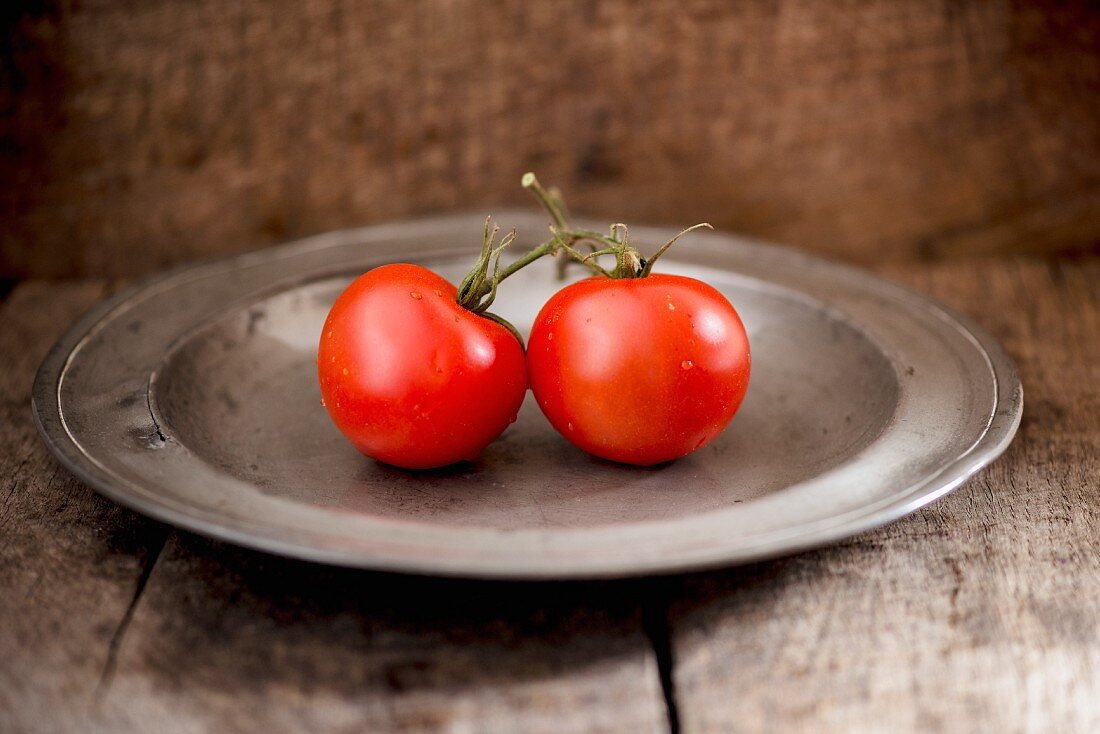 Two tomatoes on a metal plate