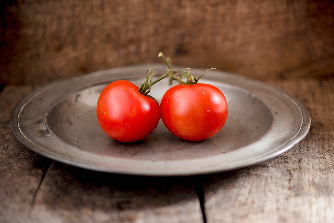 Zwei Tomaten auf Metallteller