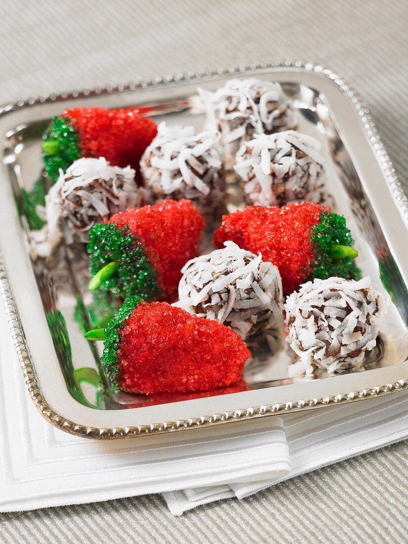 Chocolate and coconut balls and strawberry confectionery on a silver tray