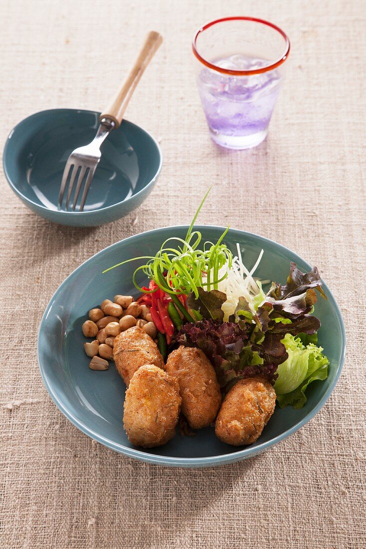 Rice croquettes with a side salad and peanuts