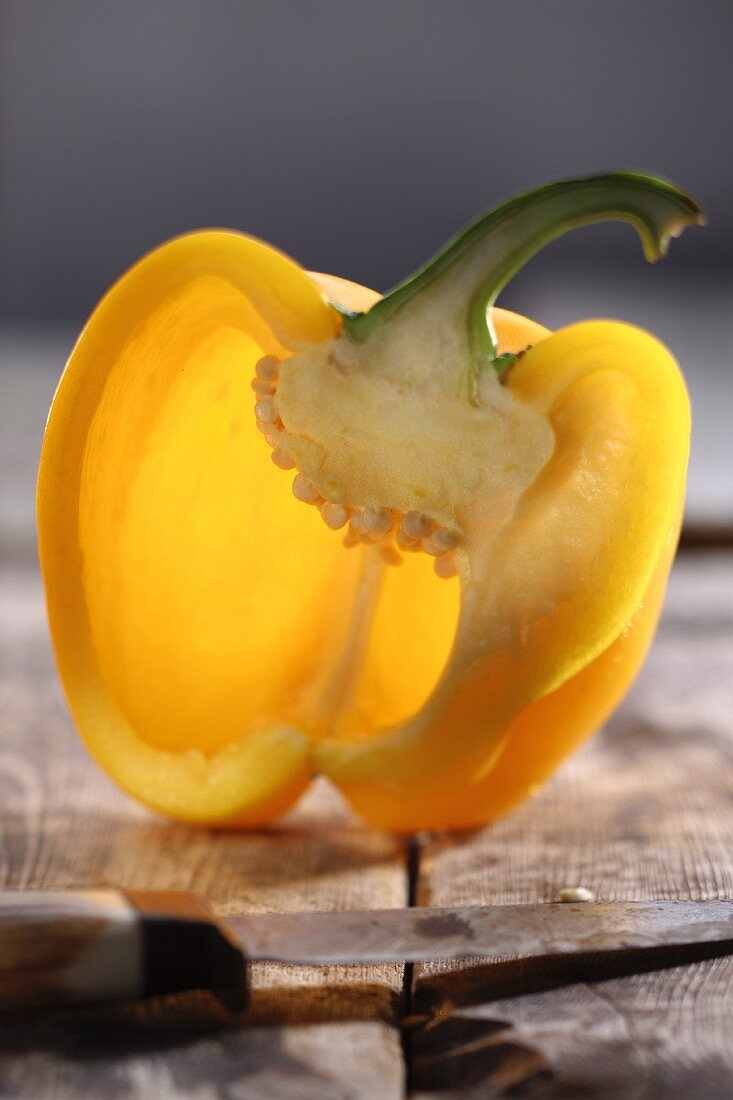 Half a yellow pepper on a wooden table