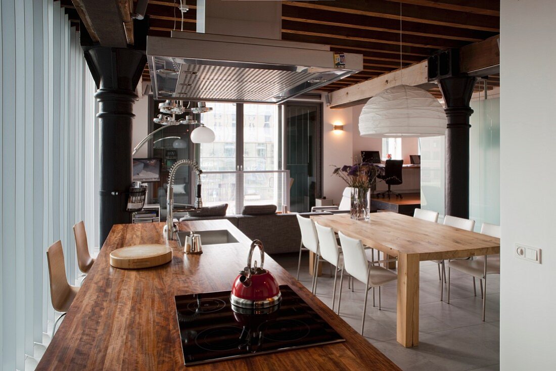 Kücheninsel mit rustikaler Holz-Arbeitsplatte und moderner Essplatz in einer Loft-Wohnung