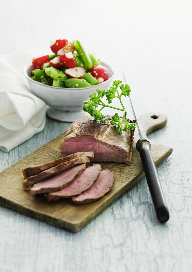 Sliced roast beef with a radish and vegetable salad