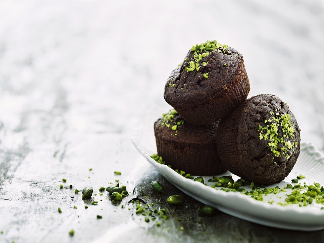 Three chocolate muffins with pistachios