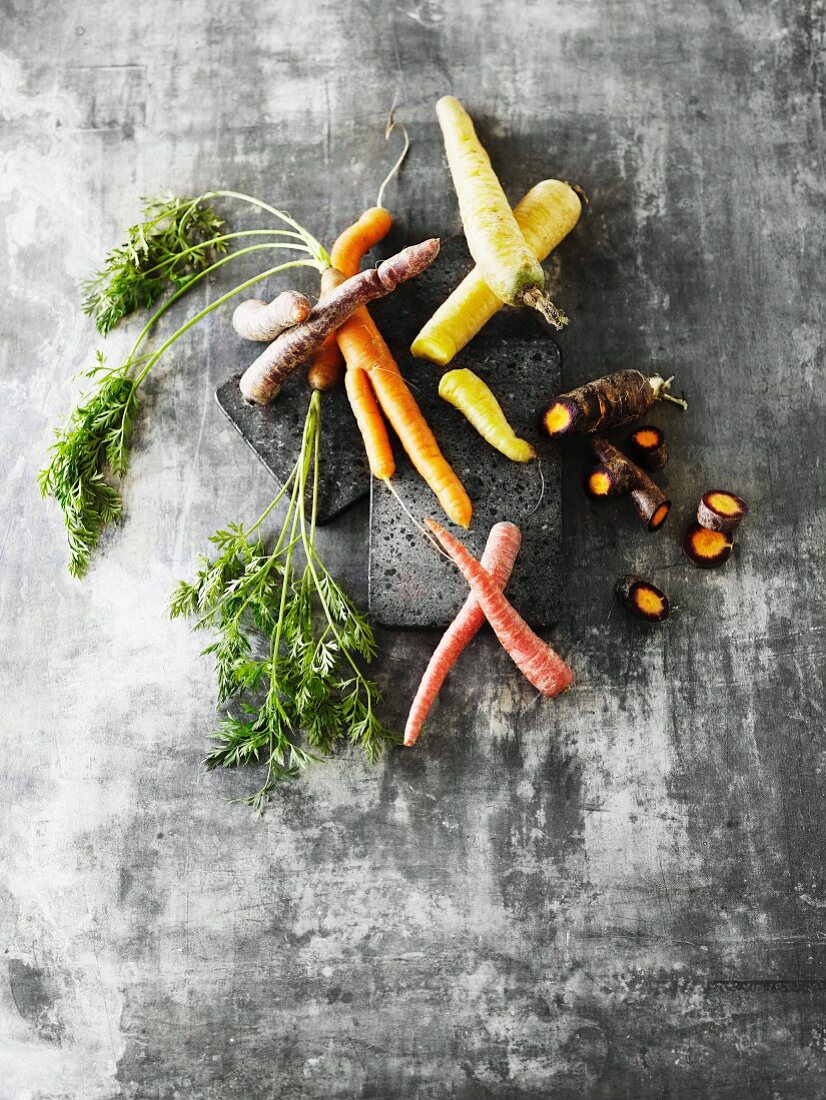 Colourful carrots, some with leaves and some sliced