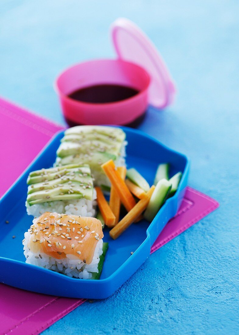Rice appetisers with salmon and avocado in a lunch box
