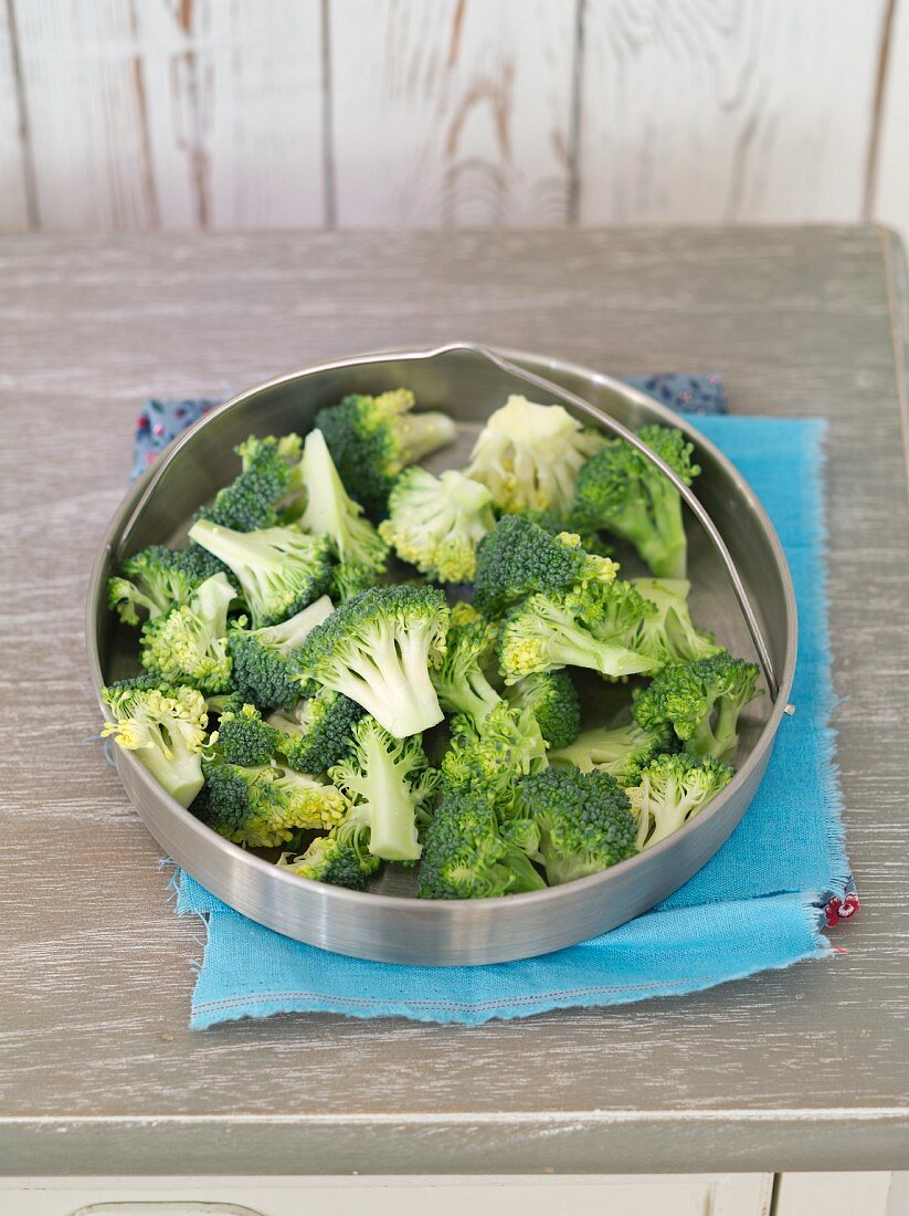 Broccoli florets in a steamer insert