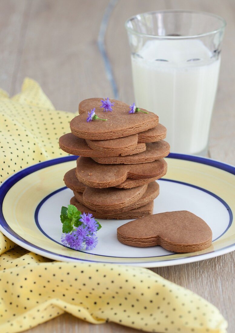 Gestapelte Erdnussbutter-Schokoladen-Cookies (Herzen und Sterne) mit einem Milchglas