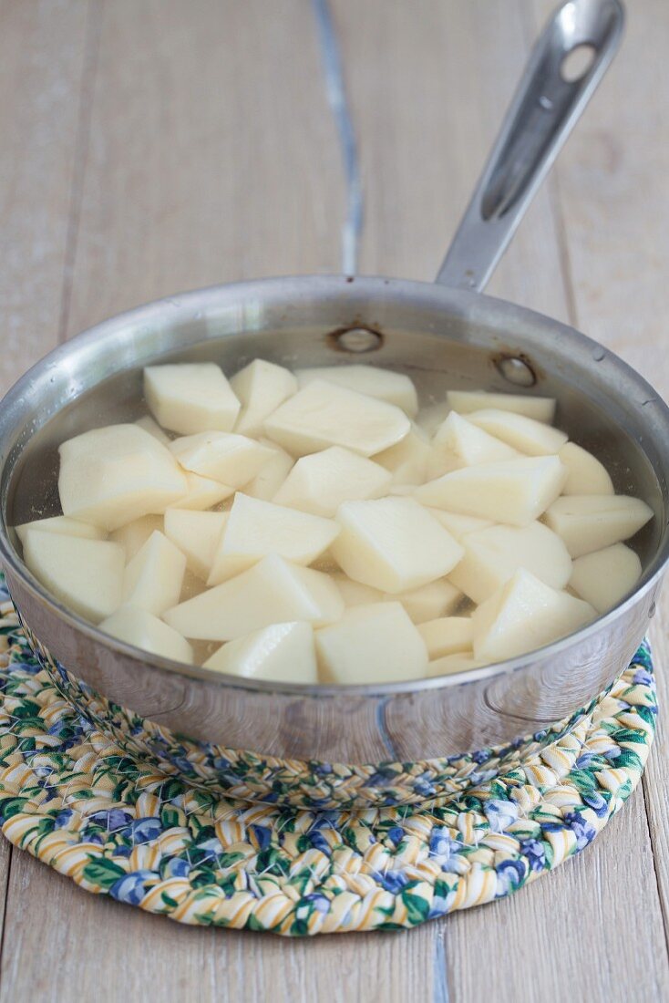 Geschälte und gewürfelte Kartoffeln in einem Topf mit Wasser