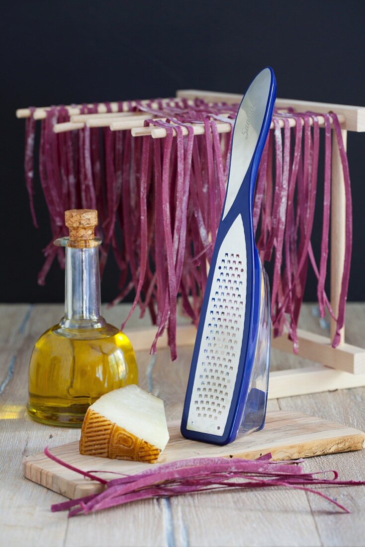 Beetroot pasta hung to dry with olive oil and cheese
