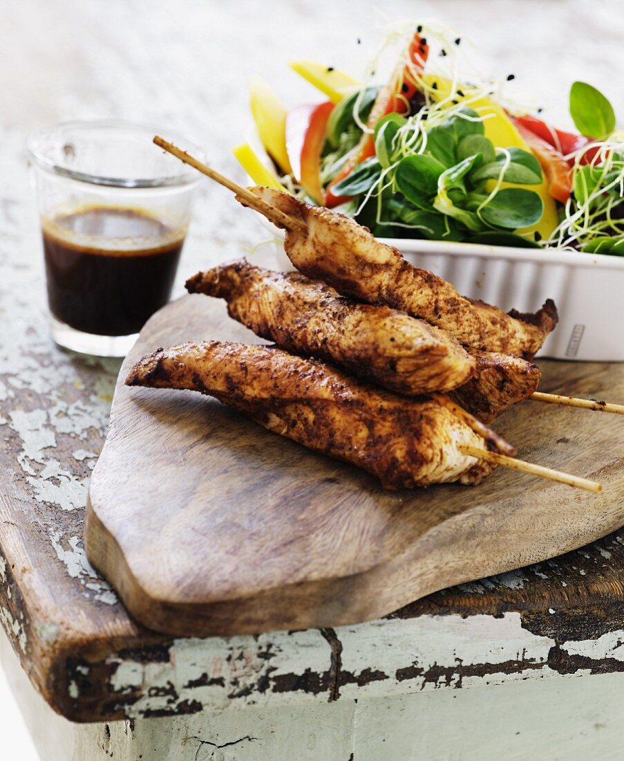 Tandoori chicken skewers with a colourful salad and a dressing