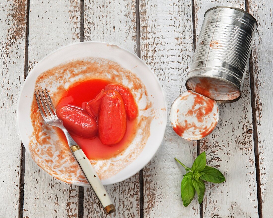 Tinned tomatoes on a plate with the empty tin next to it