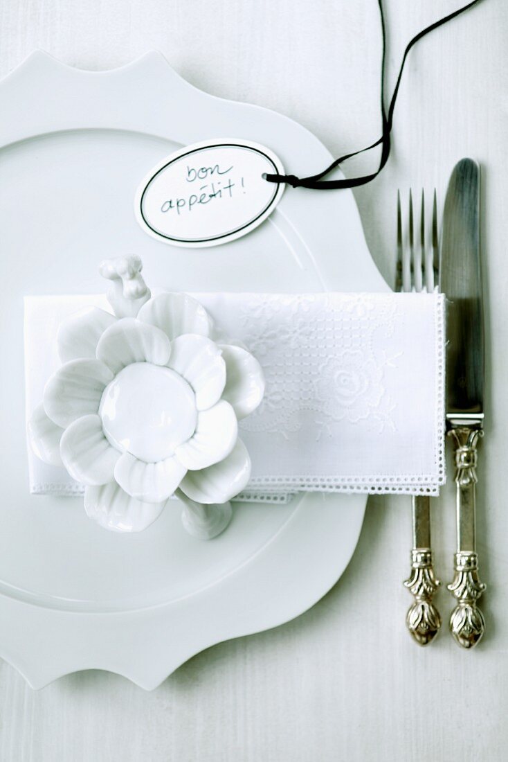 White place setting with china flower and tag labelled 'Bon appétit'