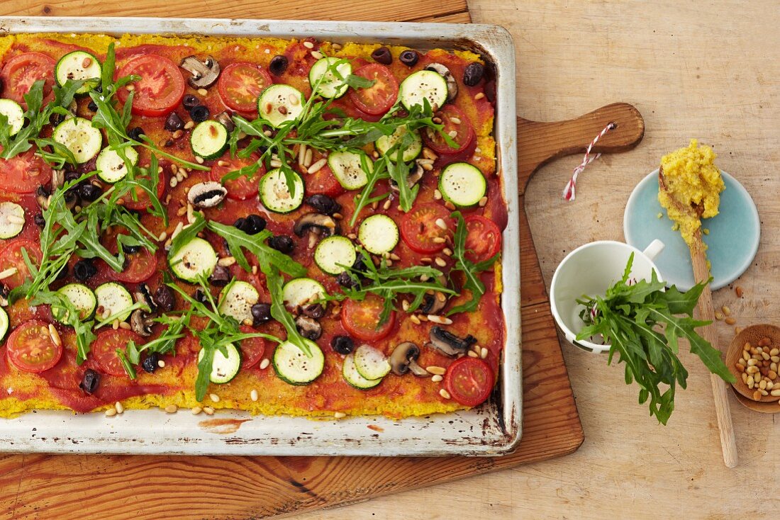 Polenta pizza with courgette, tomatoes, olives and rocket
