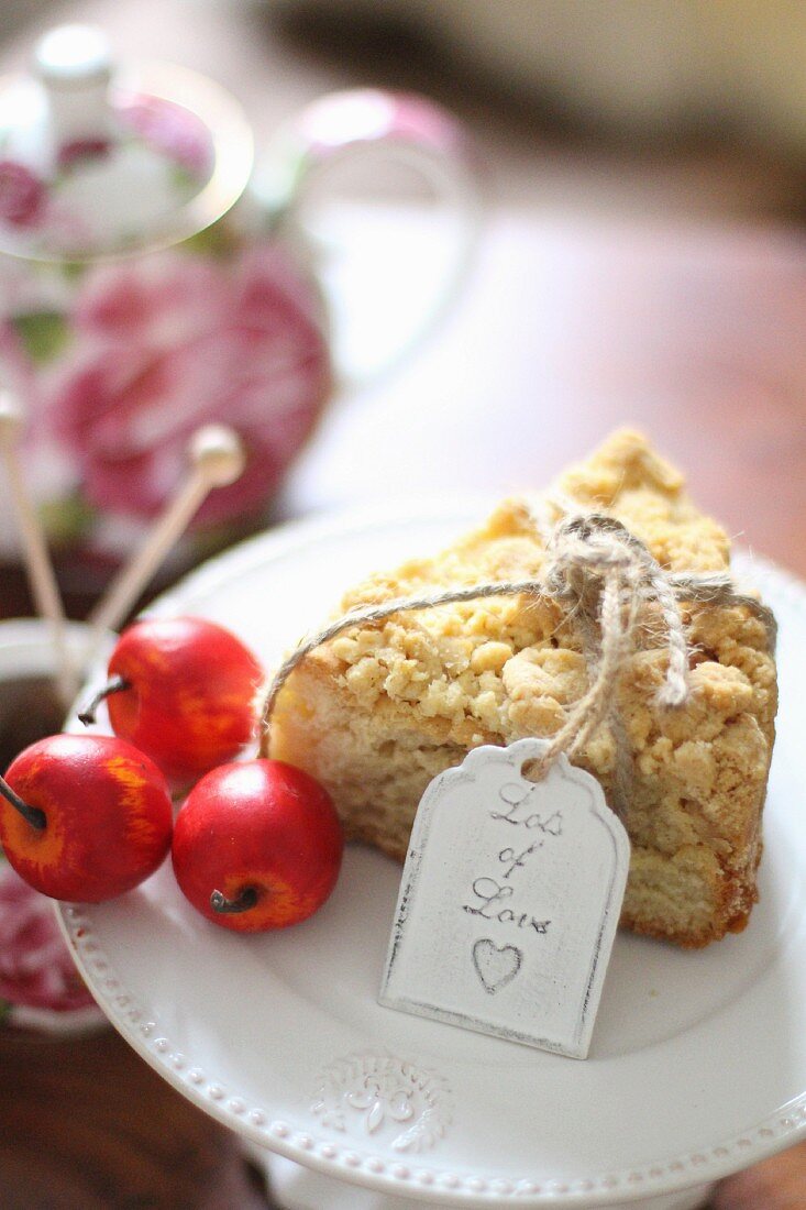A slice of apple crumble cake with a teapot in the background