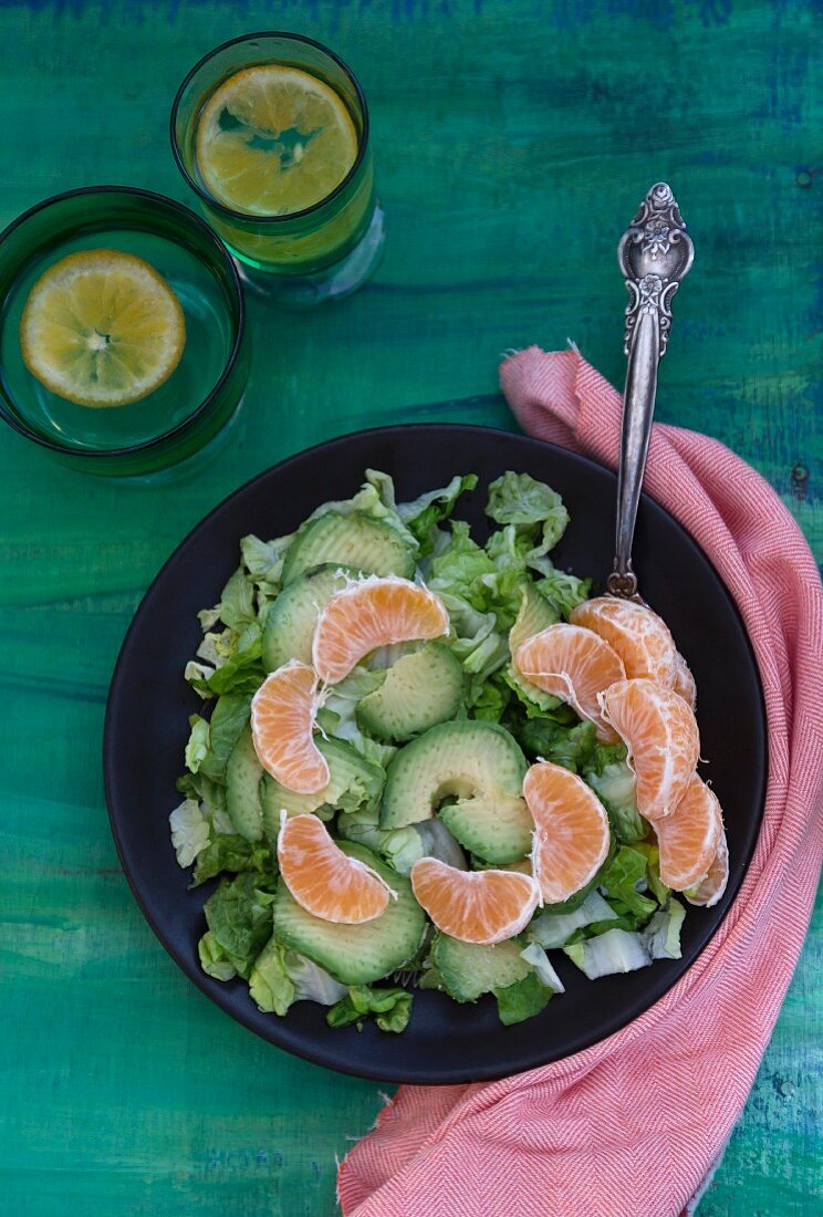 A mixed leaf salad with avocado and clementines