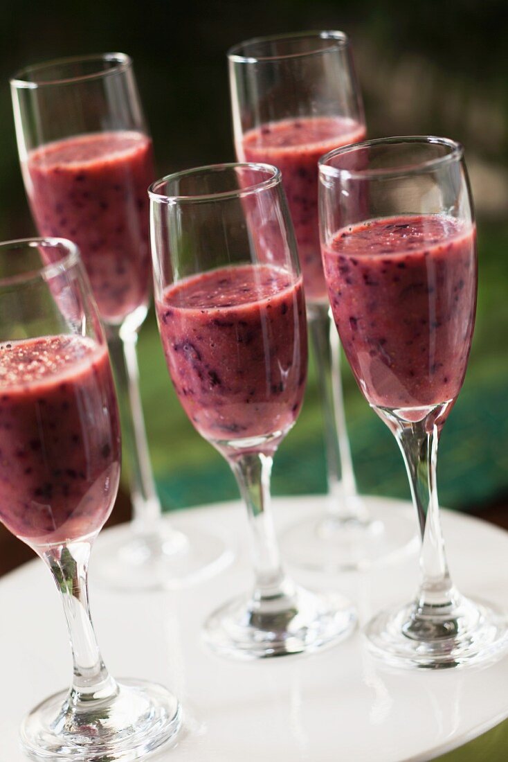 Blueberry and strawberry smoothies in stemmed glasses