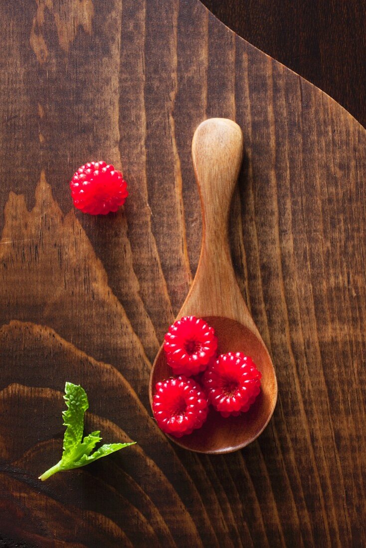 Wild raspberries on a wooden spoon (close-up)