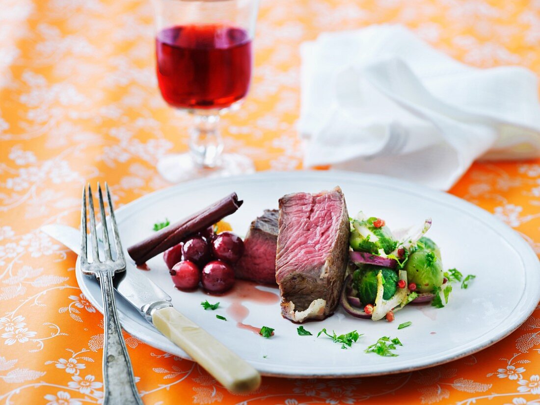 Beef steaks with cranberry sauce and Brussels sprouts