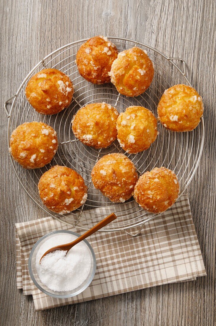 Chouquettes with sugar crystals on a cooling rack