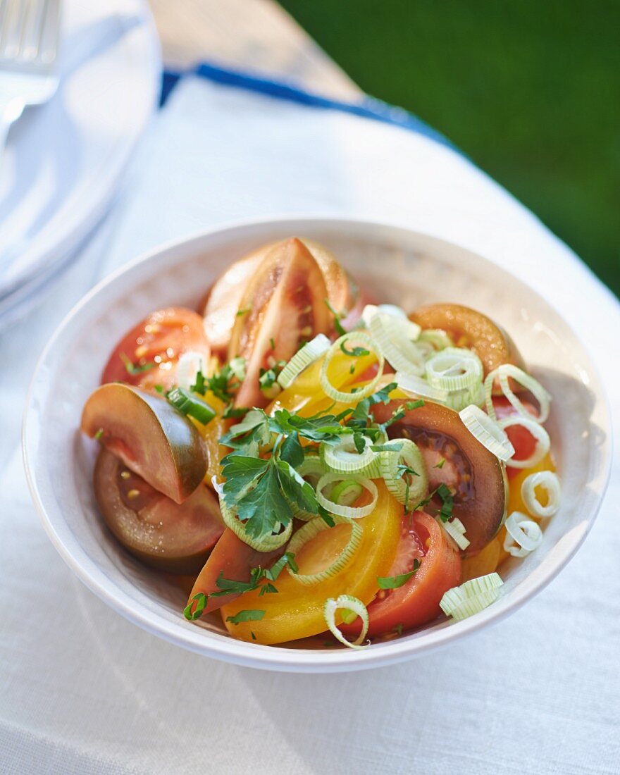 A colourful tomato salad with spring onions and parsley