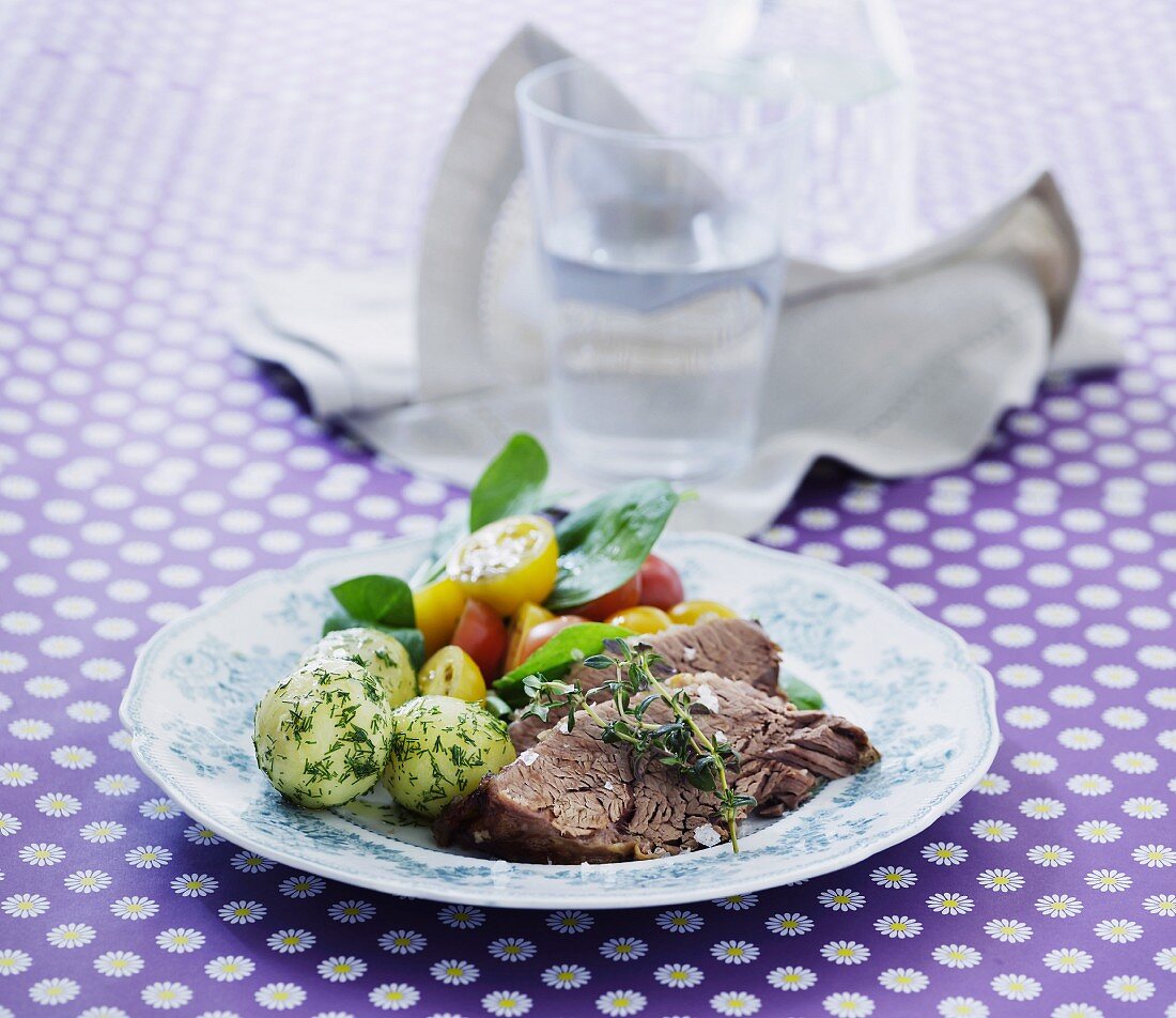 Boiled beef with dill potatoes and a colourful tomato salad