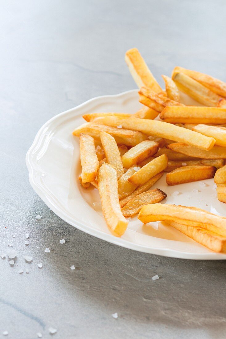 Chips on a white plate with sea salt