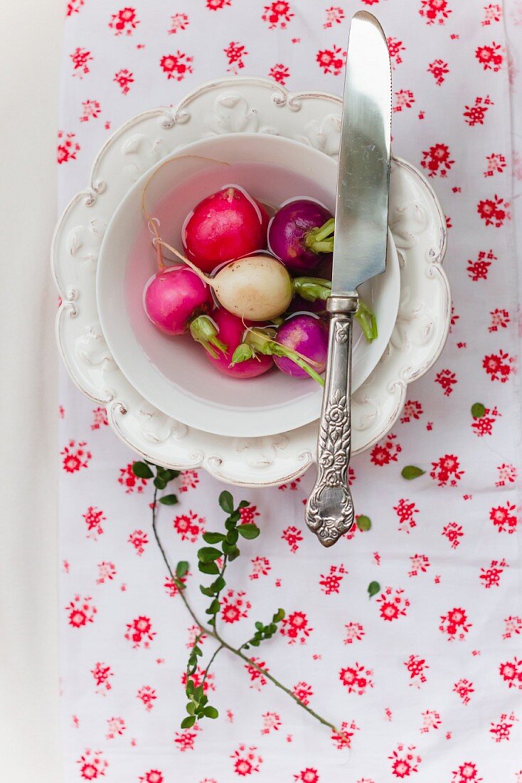 Fresh radishes in a bowl of water