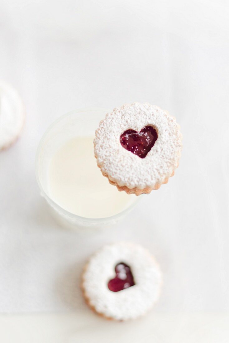 Linzer Augen (nutty shortcrust jam sandwich biscuits with holes on top) and a glass of milk for Christmas