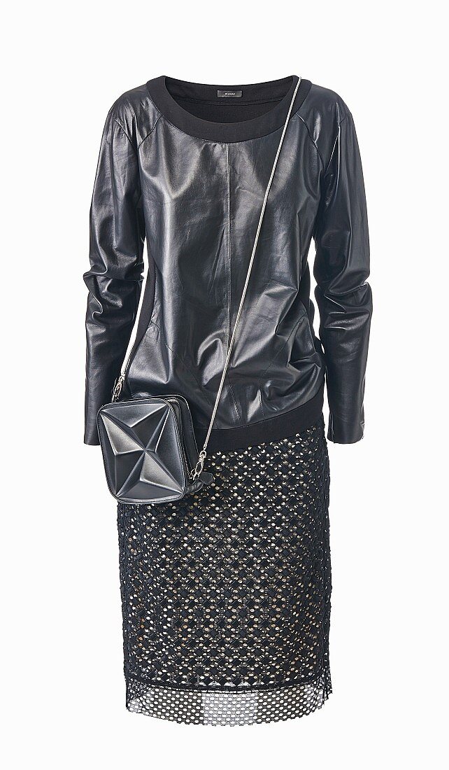 A black leather sweater with a patterned skirt and a shoulder bag