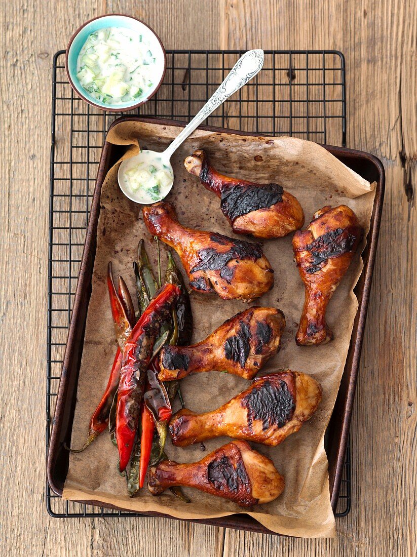 Grilled chicken drumsticks with chilli peppers and cucumber raita