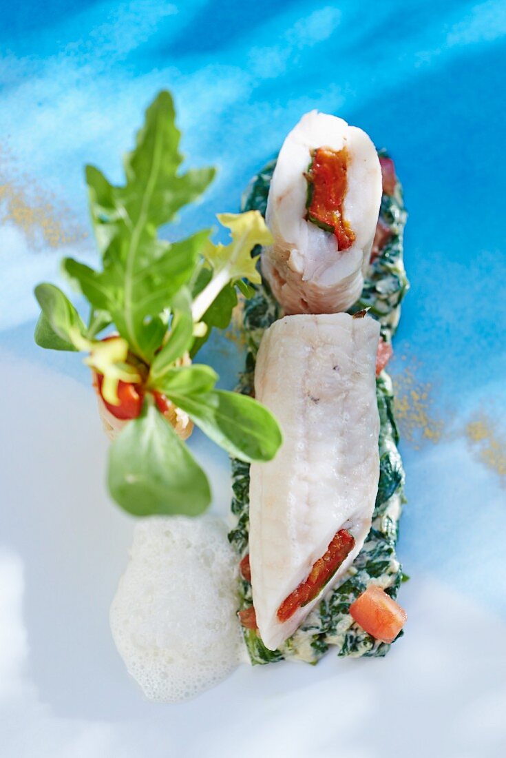 Stuffed fish rolls on a bed of spinach