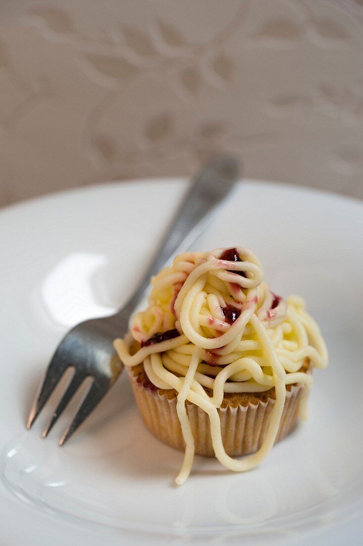 A cupcake with buttercream spaghetti and sauce