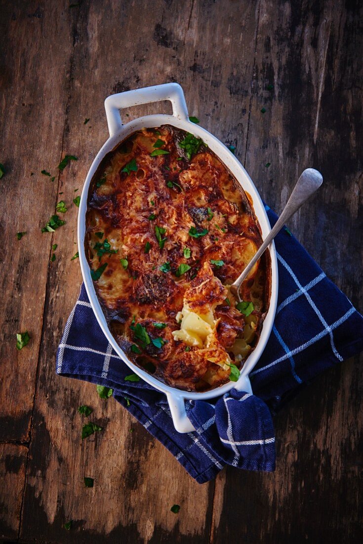 Potato gratin with parsley in a baking dish