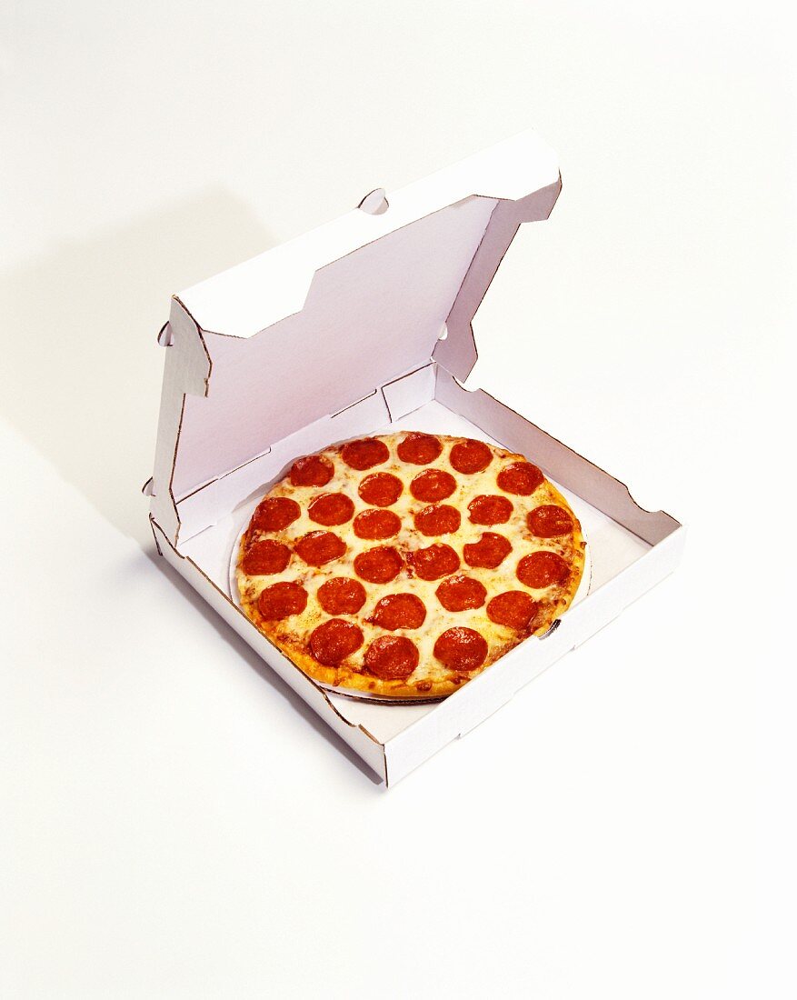 Pizza mit Peperoniwurst im Pizzakarton
