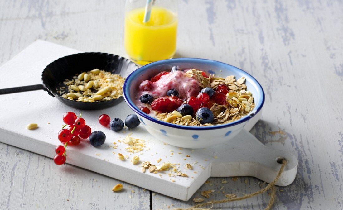 Spelt muesli with fresh berry and soy yoghurt, wheat germ and roasted pine nuts