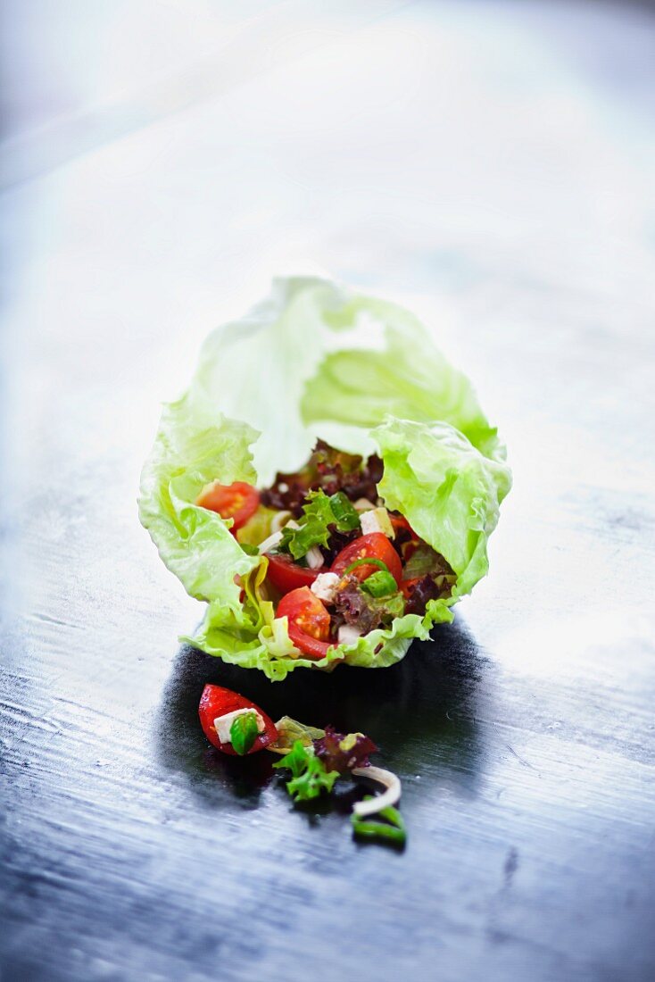 Tomato salad with feta cheese on a lettuce leaf