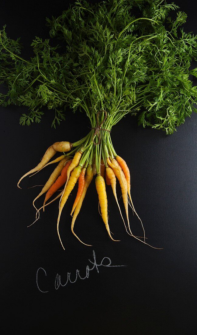 Carrots on a slate surface with a label