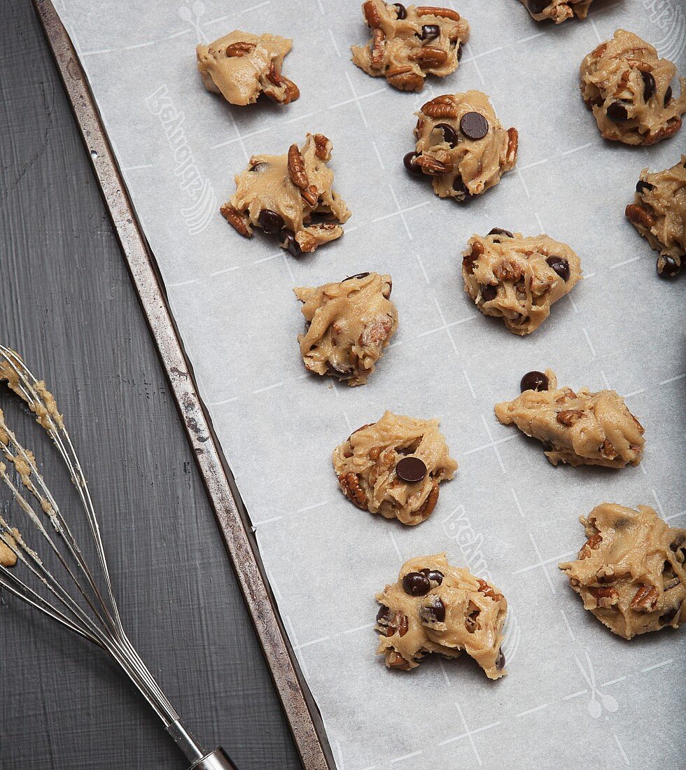 Ungebackene Chocolatechip-Pecannuss-Cookies auf Backpapier