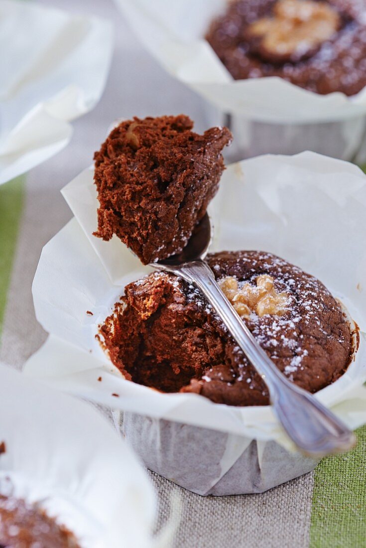 A brownie with walnuts and icing sugar