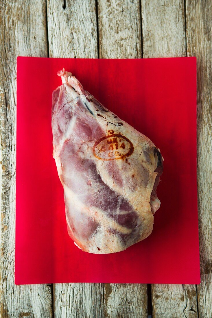 A British leg of lamb with a stamp on a red board