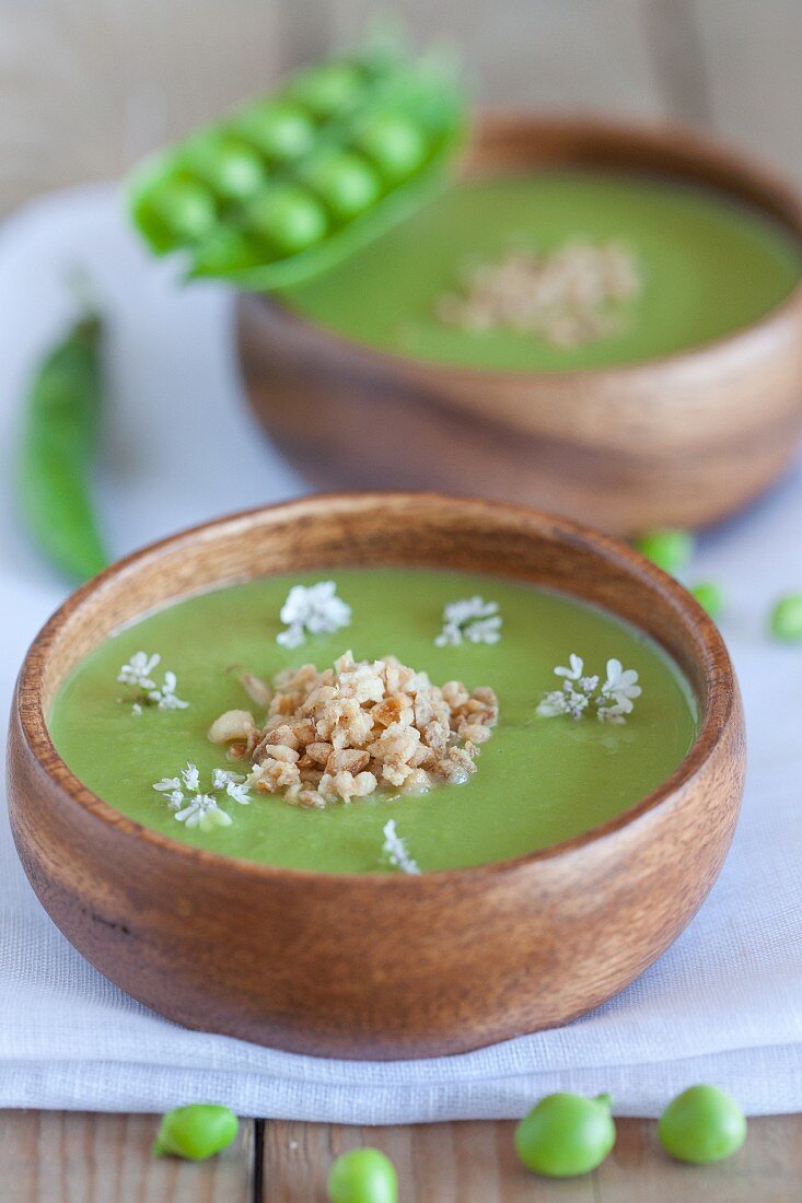 Two bowls of pea soup and fresh peas